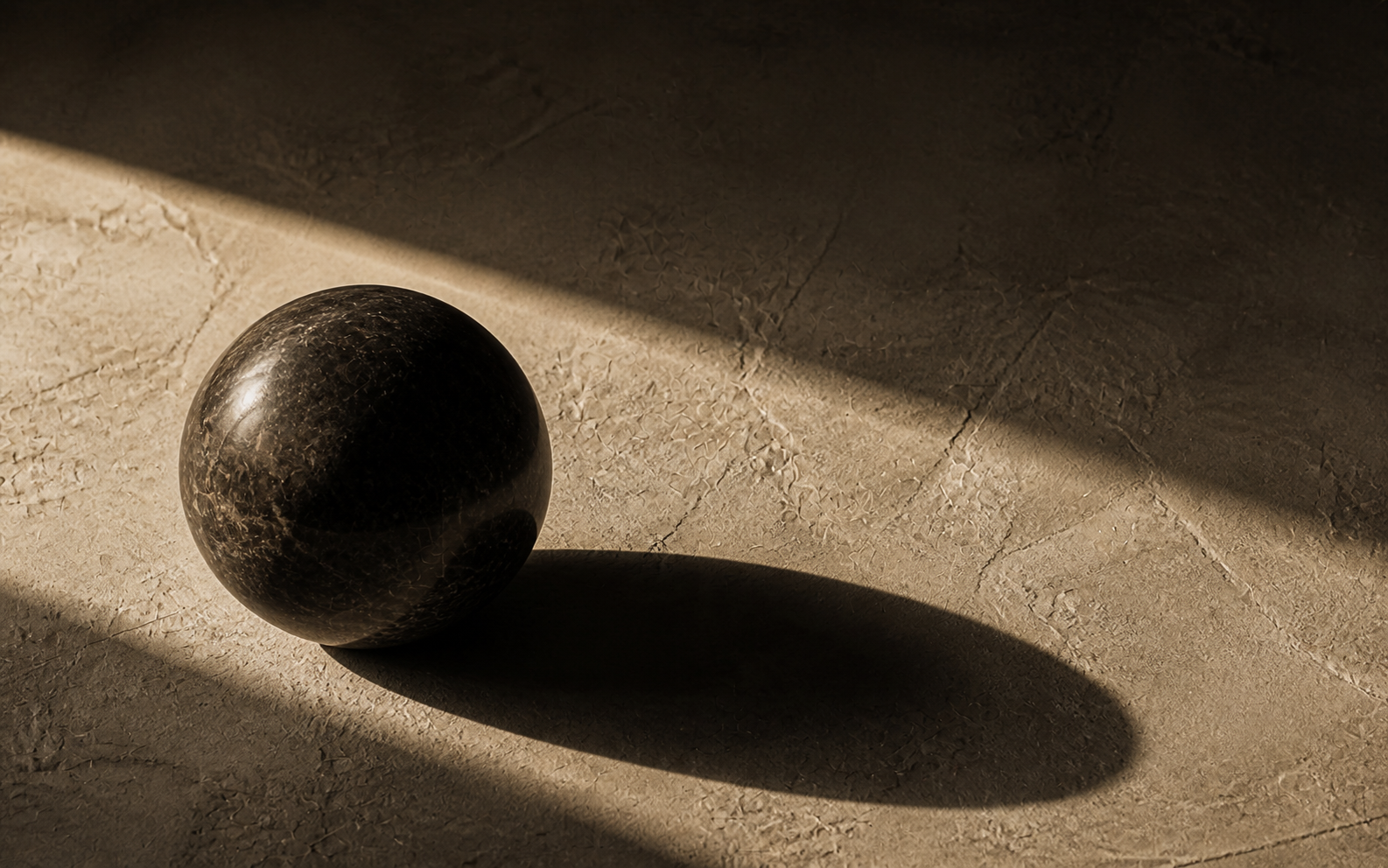 A dark stone sphere and its long shadow